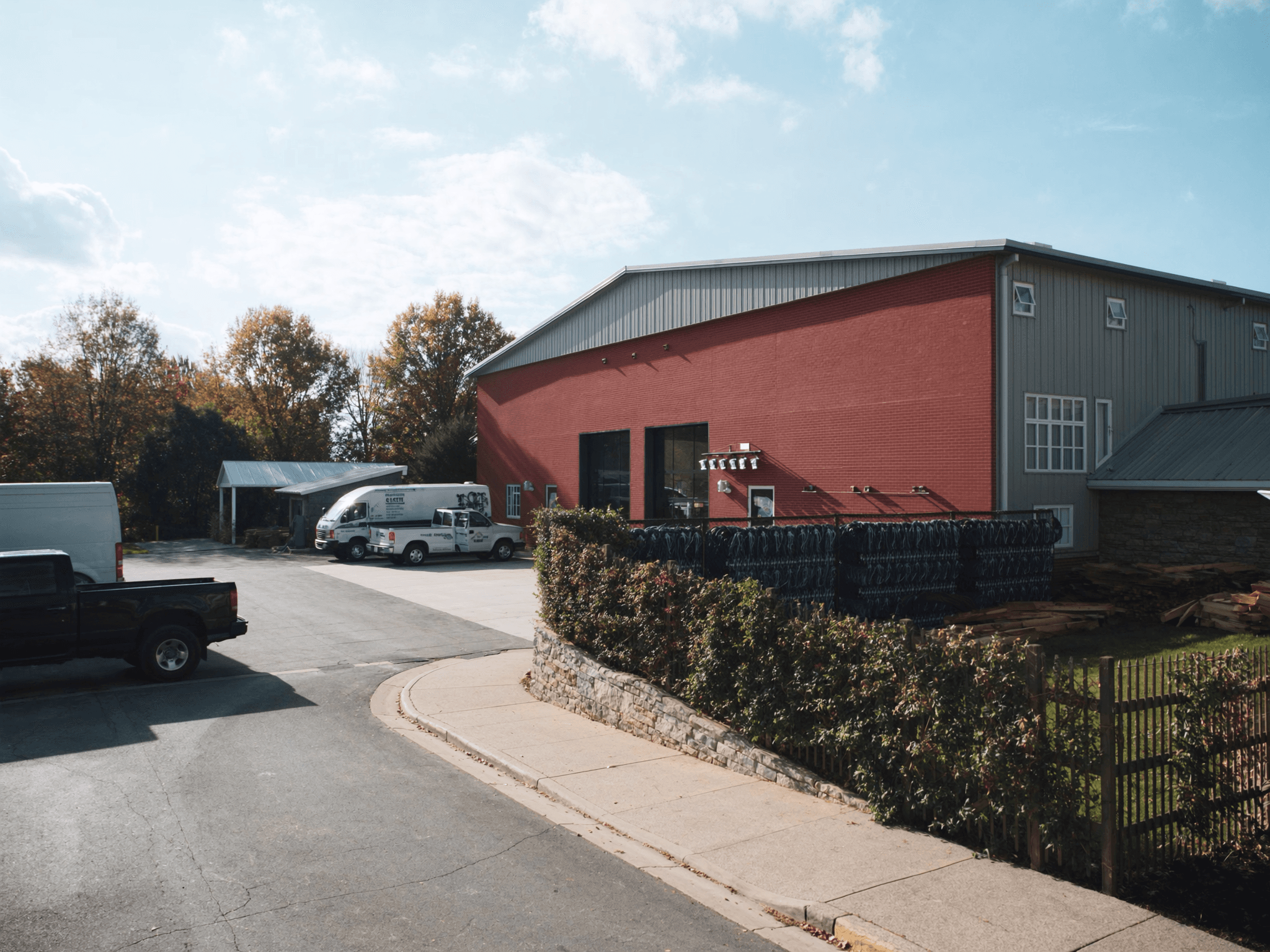 Brick industrial building with work vans in the yard